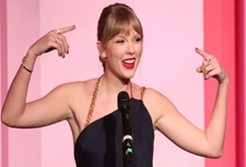 Taylor Swift speaking at a ceremony.
